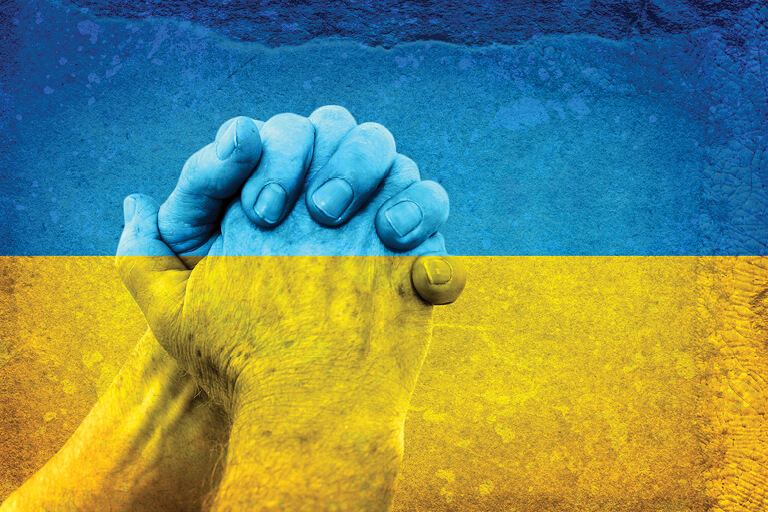 Hands holding with a Ukrainian Flag overlayed on top.